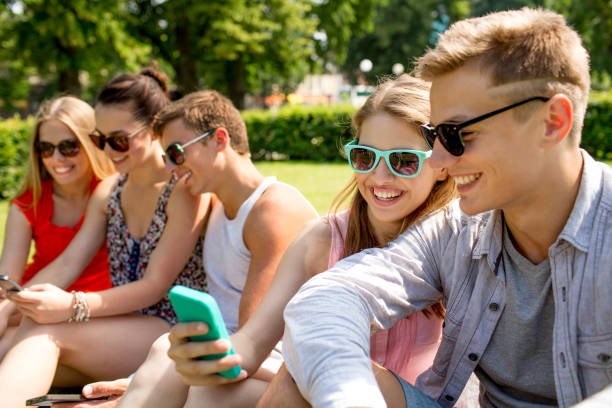 istock smiling friends with smartphone making selfie 1207295073