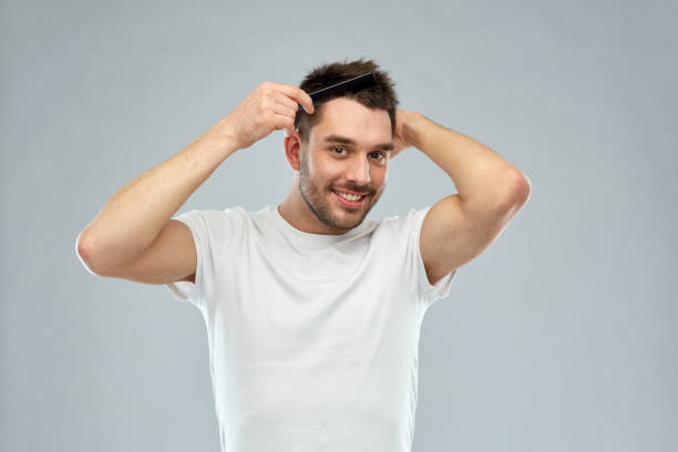 istock happy man brushing hair with comb over gray 1207296591