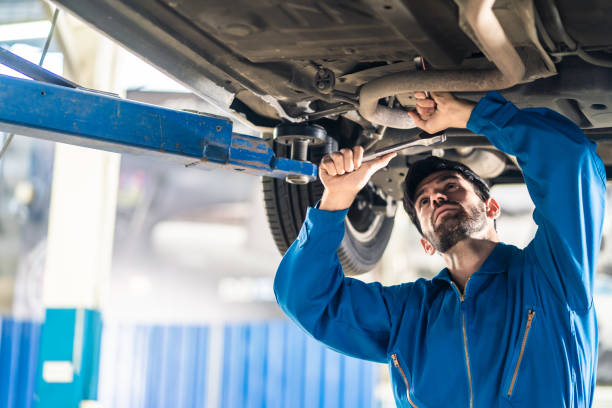 Vehicle service maintenance handsome mens checking under car condition on lifter hoist in garage. Automotive mechanic man use tool to tighten and replace damaged or broken part. Repair service concept Vehicle service maintenance handsome mens checking under car condition on lifter hoist in garage. Automotive mechanic man use tool to tighten and replace damaged or broken part. Repair service concept hoisting stock pictures, royalty-free photos & images