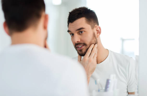 istock happy young man looking to mirror at home bathroom 1207296990