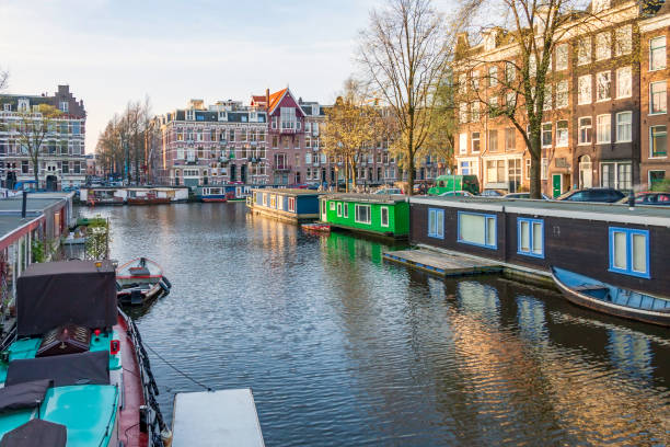 istock Amsterdam in spring means house boats along tree-lined canals and streets - with history everywhere you look - all under a blue morning sky. 1207297241