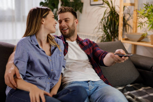 istock Young romantic couple at home watching TV 1207297925