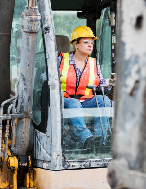 istock Hispanic female construction worker driving earth mover 1207298404