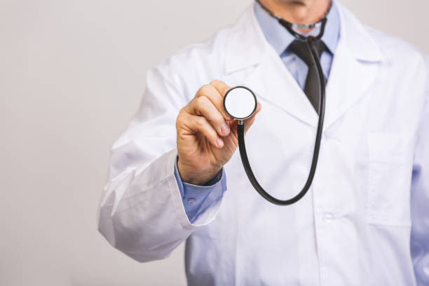 istock Senior doctor uses the phonendoscope stethoscope isolated on a grey background. 1207299025