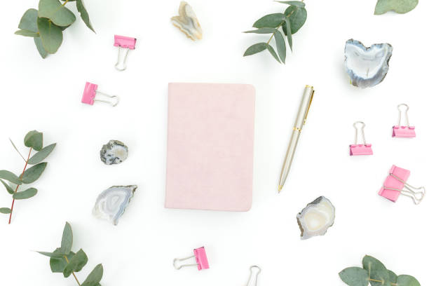 istock Floral composition with notebook, eucalyptus, roses flowers and Agate stones on white background. Flat lay 1207300018
