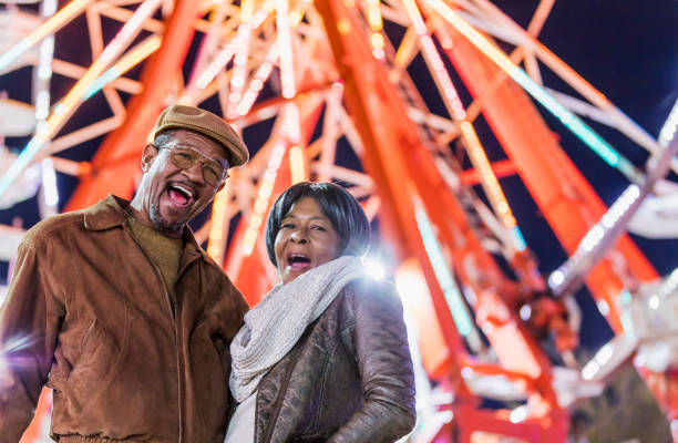 istock Senior couple at county fair by ferris wheel 1207300152