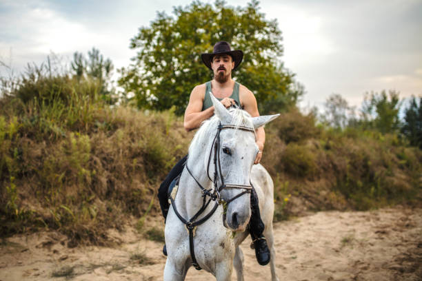 istock Handsome man enjoys riding horses in nature 1207300258