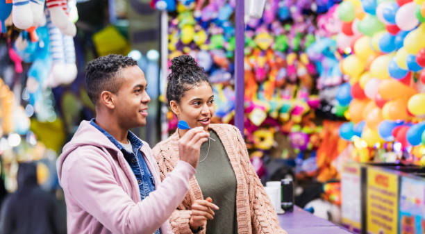 istock Young African-American couple playing carnival game 1207300268