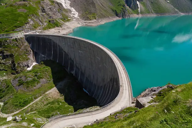 Tourists walking on big concrete Dam, Kaprun, Austria