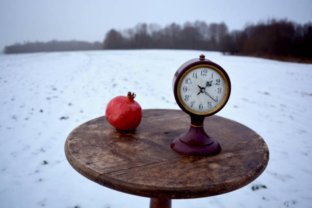 natura morta invernale con melograno e orologio antico sul tavolo - 7292 foto e immagini stock