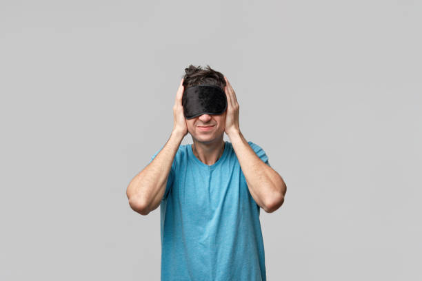 sleepy man with black sleep mask on a head screaming closing ears isolated over grey background - clock clock face blank isolated imagens e fotografias de stock