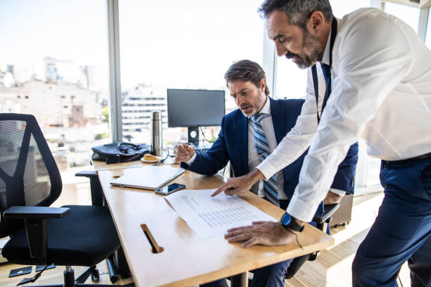 istock Businessmen looking at document and discussing about work in office 1207305738