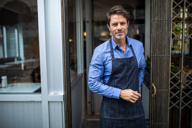 istock Handsome entrepreneur standing in front of cafe 1207306188