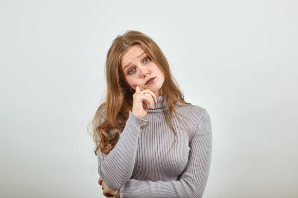 istock beautiful red haired woman in gray sweater thinks pityingly looks forward 1207307760