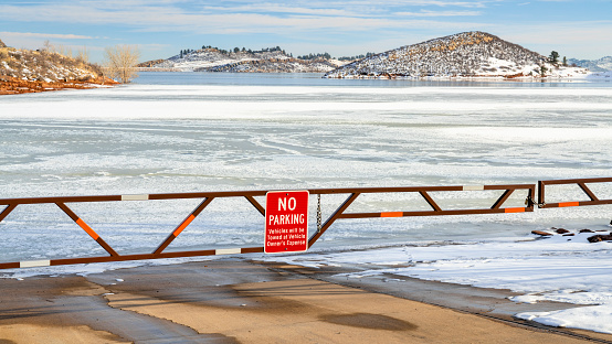 Boat ramp closed for winter on a frozen lake at foothills of Rocky Mountains - Horsetooth Reservoir, a popular recreation destination near Fort Collins in northern Colorado.