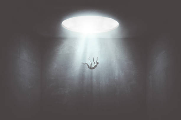 man falling down from a hole of light, surreal concept - light shadow lighting equipment inspiration imagens e fotografias de stock