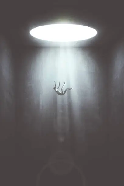 man falling down from a hole of light, surreal concept