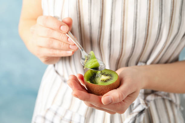 istock Woman eating a kiwi with a spoon, close up 1207310283