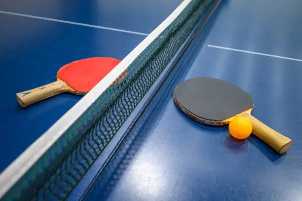 Ping pong table tennis bats and yellow ball