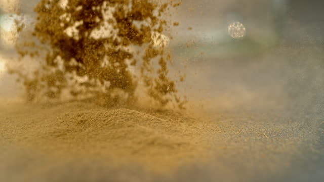 SLO MO LD Powdered ginger falling onto a surface