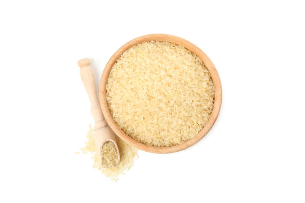 istock Wooden bowl and scoop with rice isolated on white background 1207313916
