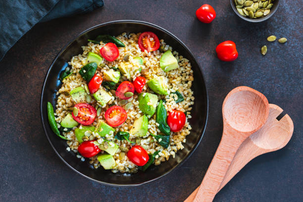 Healthy salad with bulgur, avocado, spinach and cherry tomatoes. Top view. Healthy salad with bulgur, avocado, spinach and cherry tomatoes. Top view. couscous stock pictures, royalty-free photos & images