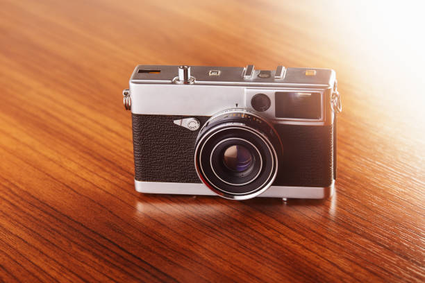 istock Vintage analog rangefinder film camera on wooden table 1207315367