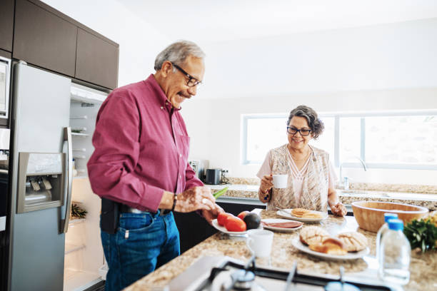 senior married couple eating healthy food for breakfast. - cooking senior adult healthy lifestyle couple imagens e fotografias de stock