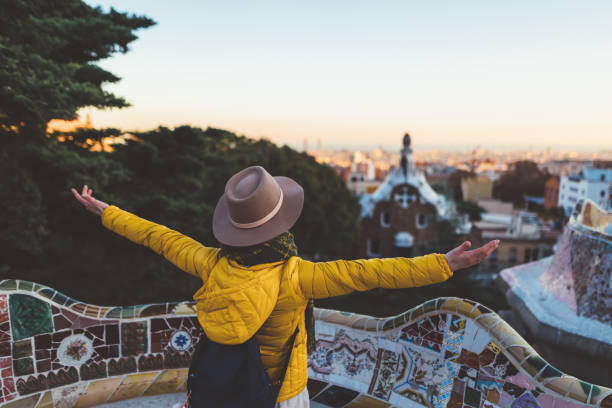 Solo traveler enjoying Barcelona Rear view of young woman with arms outstretched admiring the city exchange student stock pictures, royalty-free photos & images