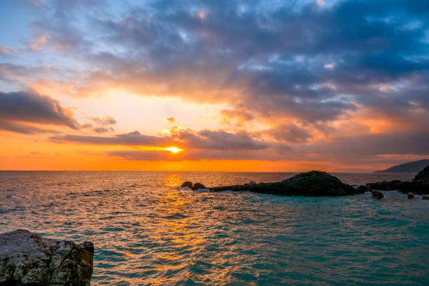 istock Sea Dawn and Sun Rays on the Rocky Shore 1207317107
