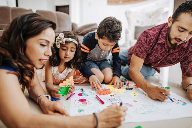 istock Creative Latin parents drawing with children at home and laughing. 1207317519