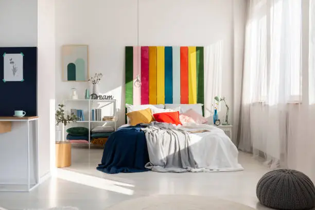 Colorful bedroom interior with rainbow colored bedhead