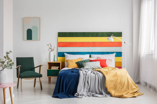 istock Retro armchair in modern bedroom interior with rainbow colored headboard 1207319267