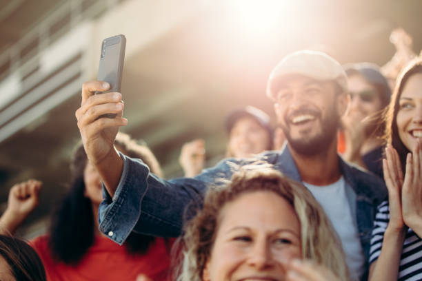istock Excited couple taking selfie at stadium 1207321032