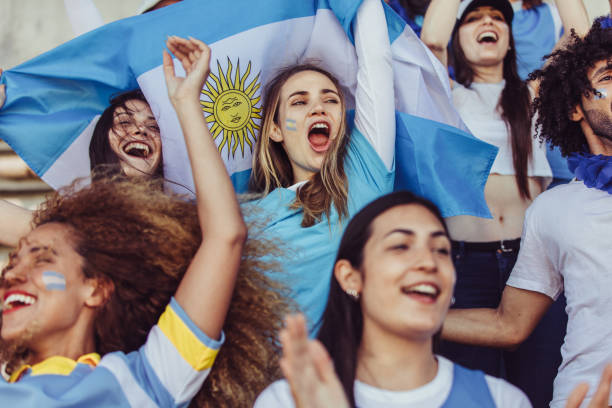 Females from Argentina cheering in fan zone Women in stadium holding a Argentina flag cheering their team. Females from Argentina in fan zone enjoying during a sports event. argentinian culture stock pictures, royalty-free photos & images