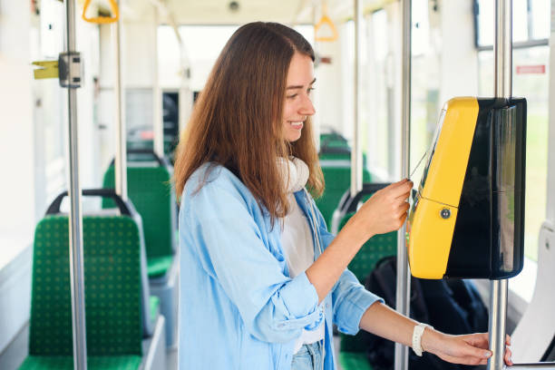 若い女性は、トラムや地下鉄で公共交通機関の銀行カードで支払います。 - bus inside of people train ストックフォトと画像