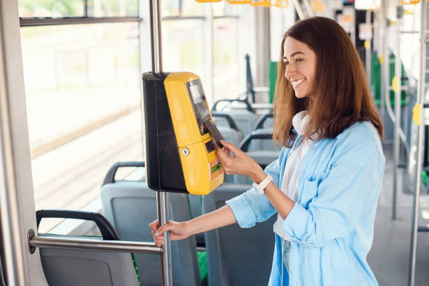 若い女性は、トラムや地下鉄で公共交通�機関の銀行カードで支払います。 - bus inside of people train ストックフォトと画像