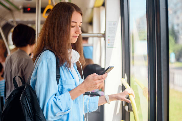 예쁜 여성 승객은 현대 트램이나 지하철에서 이동하는 동안 smartp 연마와 함께 앉아있다. 대중 교통여행. - bus commuter passenger mobile phone 뉴스 사진 이미지