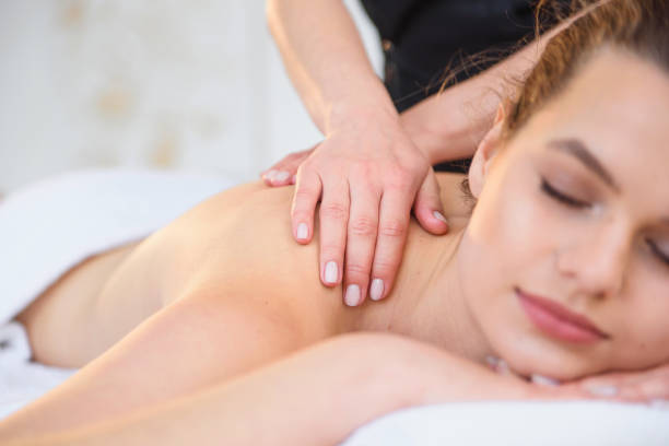 istock Young female masseur making massage in spa salon. 1207328179