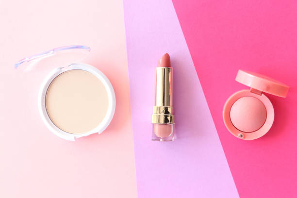 istock Spring background. Lipstick, beige powder, pink blush on multicolored bright background. Flat lay style. 1207329145