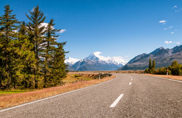 Open road to Mount Cook in New Zealand A curving road leading towards Aoraki (Mount Cook) on New Zealand's South Island. mt cook photos stock pictures, royalty-free photos & images