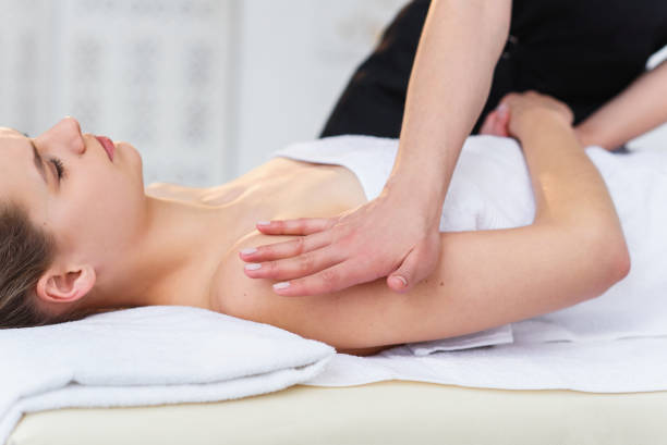 istock Young female masseur making massage in spa salon. 1207331115