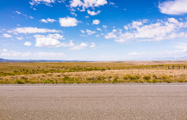 Side view of rural highway in the US A horizon of rural land in Utah, USA, with the asphalt surface of the highway in the foreground. country road stock pictures, royalty-free photos & images