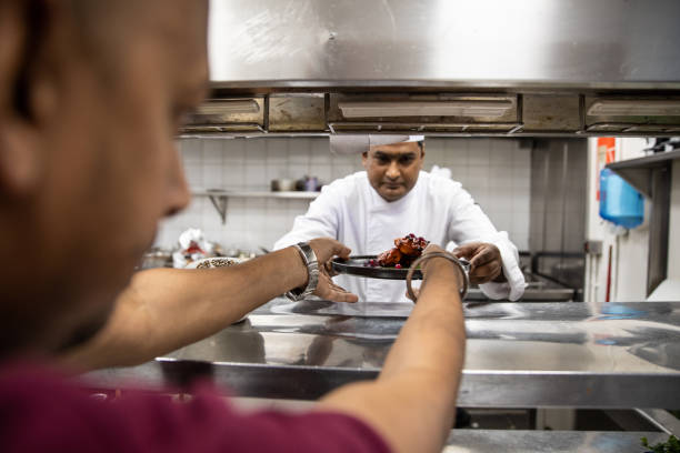 istock Chefs cooking in a professional kitchen of a gourmet restaurant 1207331184