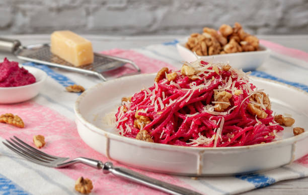 istock Spaghetti with beetroot pesto sauce, walnuts and parmesan on a light background 1207332807