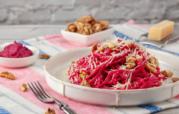 istock Spaghetti with beetroot pesto sauce, walnuts and parmesan on a light background 1207332810