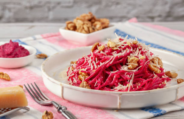 istock Spaghetti with beetroot pesto sauce, walnuts and parmesan on a light background 1207332812