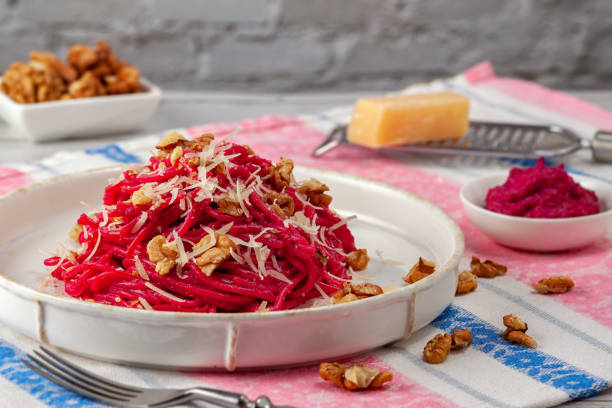 istock Spaghetti with beetroot pesto sauce, walnuts and parmesan on a light background 1207332828