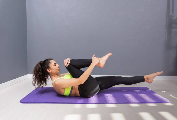istock Young woman doing pilates exercise on the floor 1207332886