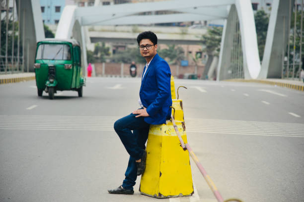 istock Man in blue suits sitting on a road divider unique photo 1207334111